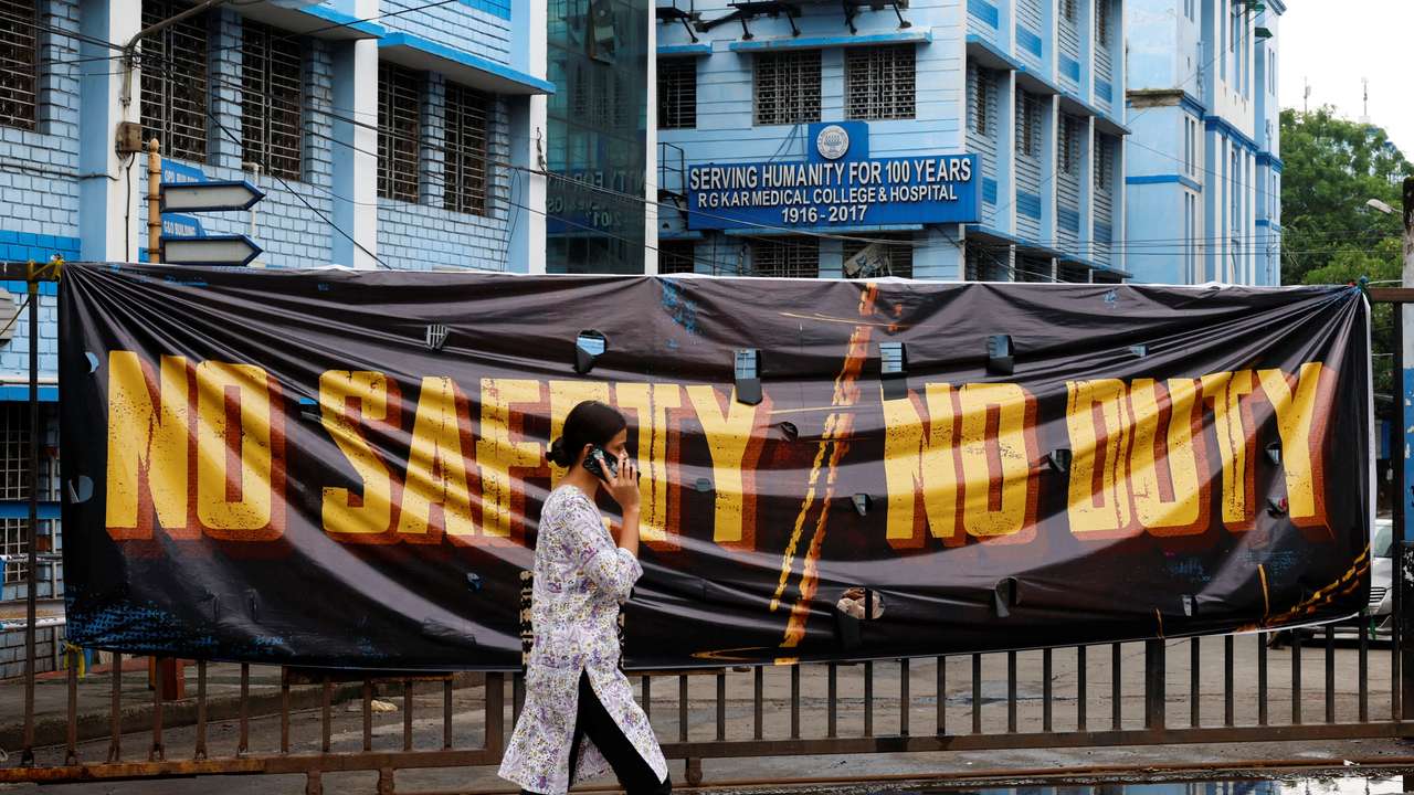 A woman walks past a closed gate of R G Kar Medical College and Hospital in Kolkata