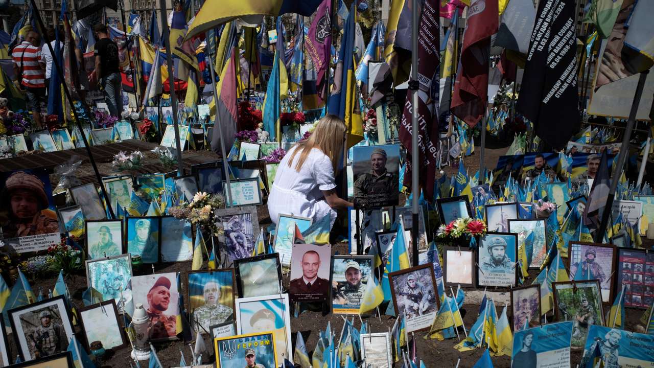 A woman pays tribute to a fallen soldier In Kyiv's Maidan Square