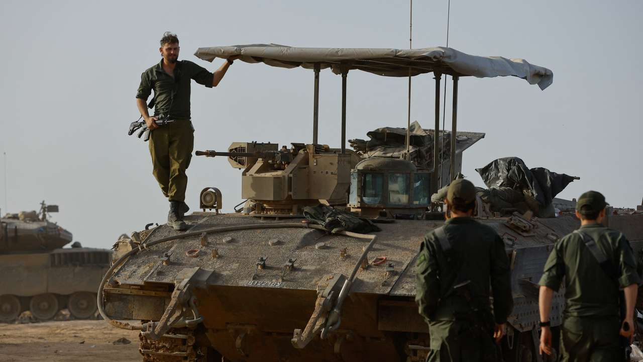 An Israeli soldier stands on an armoured personnel carrier near the Israel-Gaza border during a temporary truce between Hamas and Israel