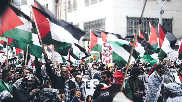 Manifestantes segurando bandeiras da Palestina
