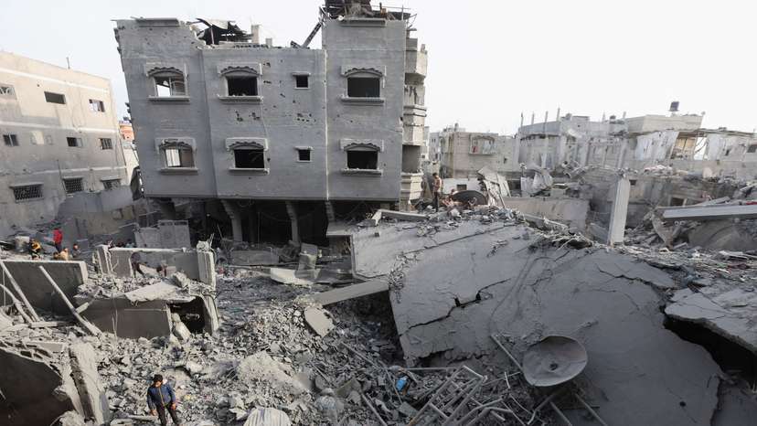 Palestinians inspect damage at the site of an Israeli strike on a house, at Nuseirat refugee camp