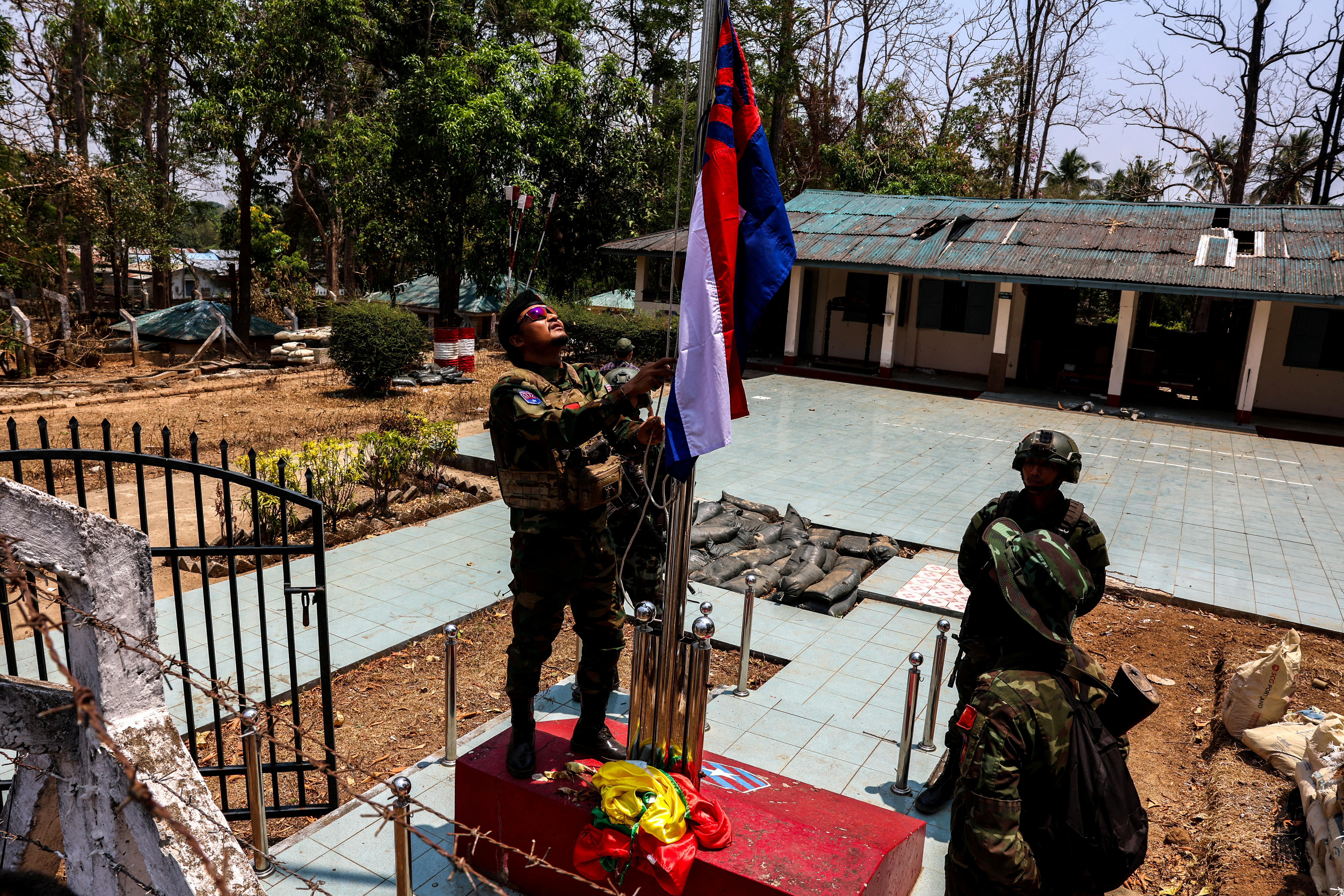 LT Saw Kaw, a soldier of the Karen National Liberation Army (KNLA) in charge of the Cobra column, raises Karen's national flag after burning Myanmar's national flag at a Myanmar military base on the outskirts of Myawaddy