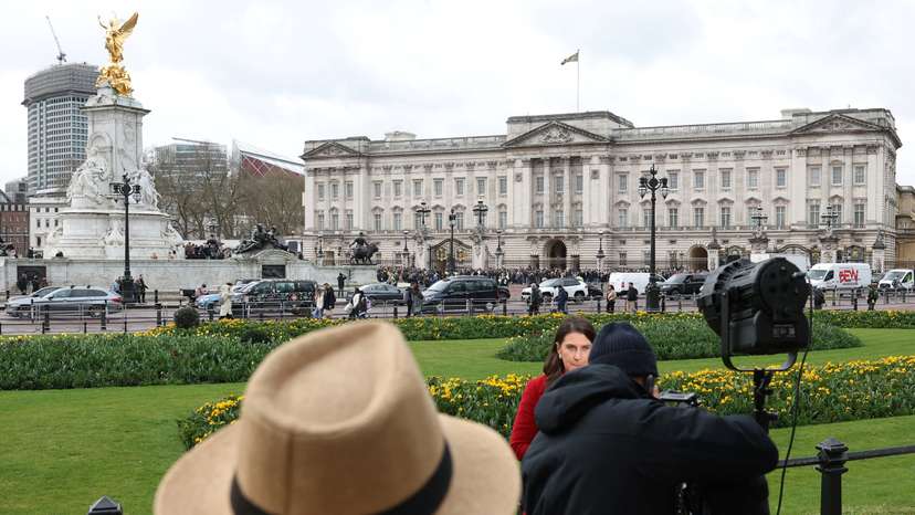 A person views members of the media broadcasting outside Buckingham Palace, as Britain's King Charles cancelled engagements after experiencing side effects from treatment for cancer,in London