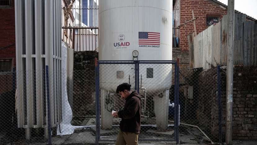 A man walks past the liquid oxygen storage tank installed at Bir Hospital by the United States Agency for International Development (USAID), in Kathmandu
