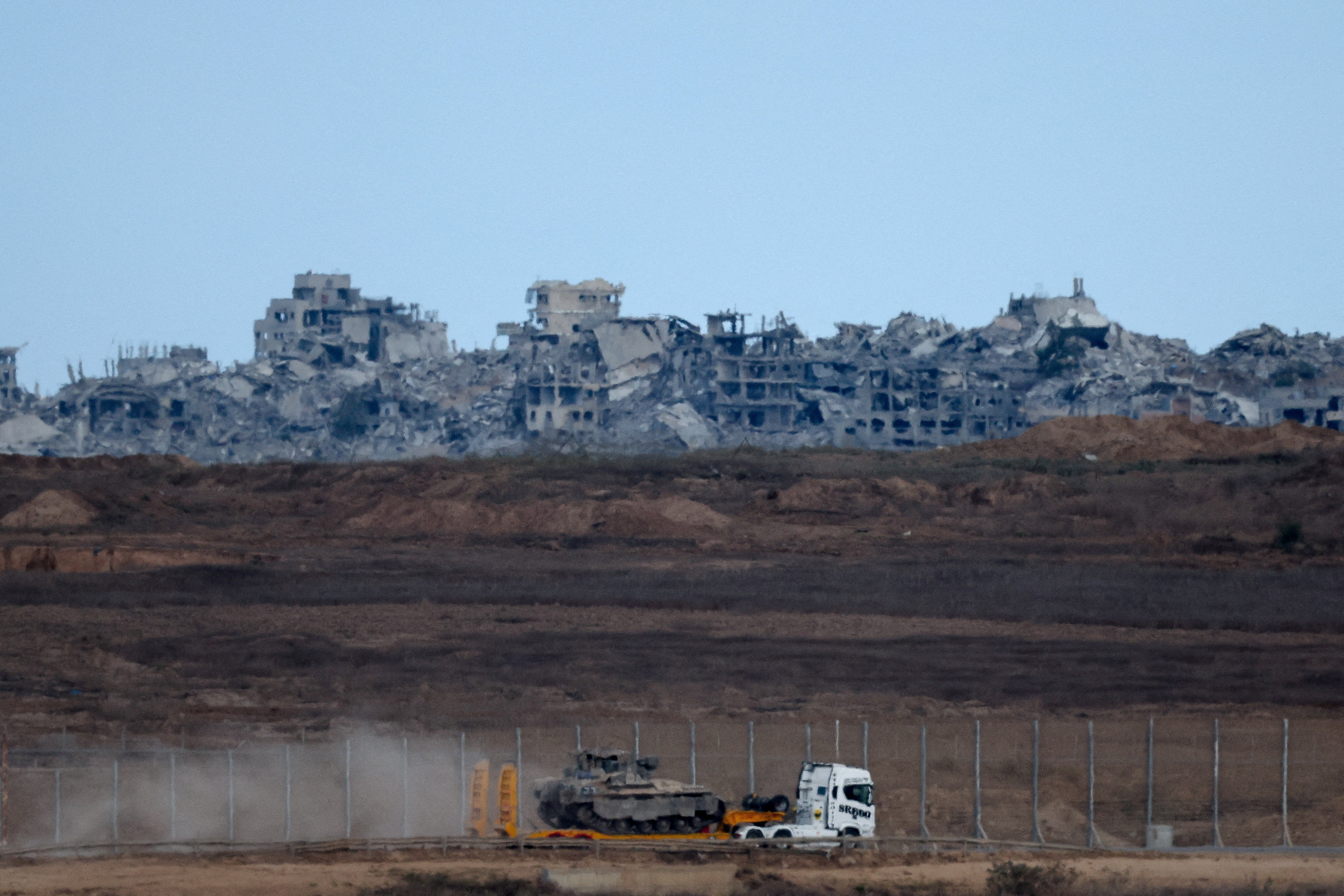 Truck transports Israeli APC in Israel near the border with Gaza