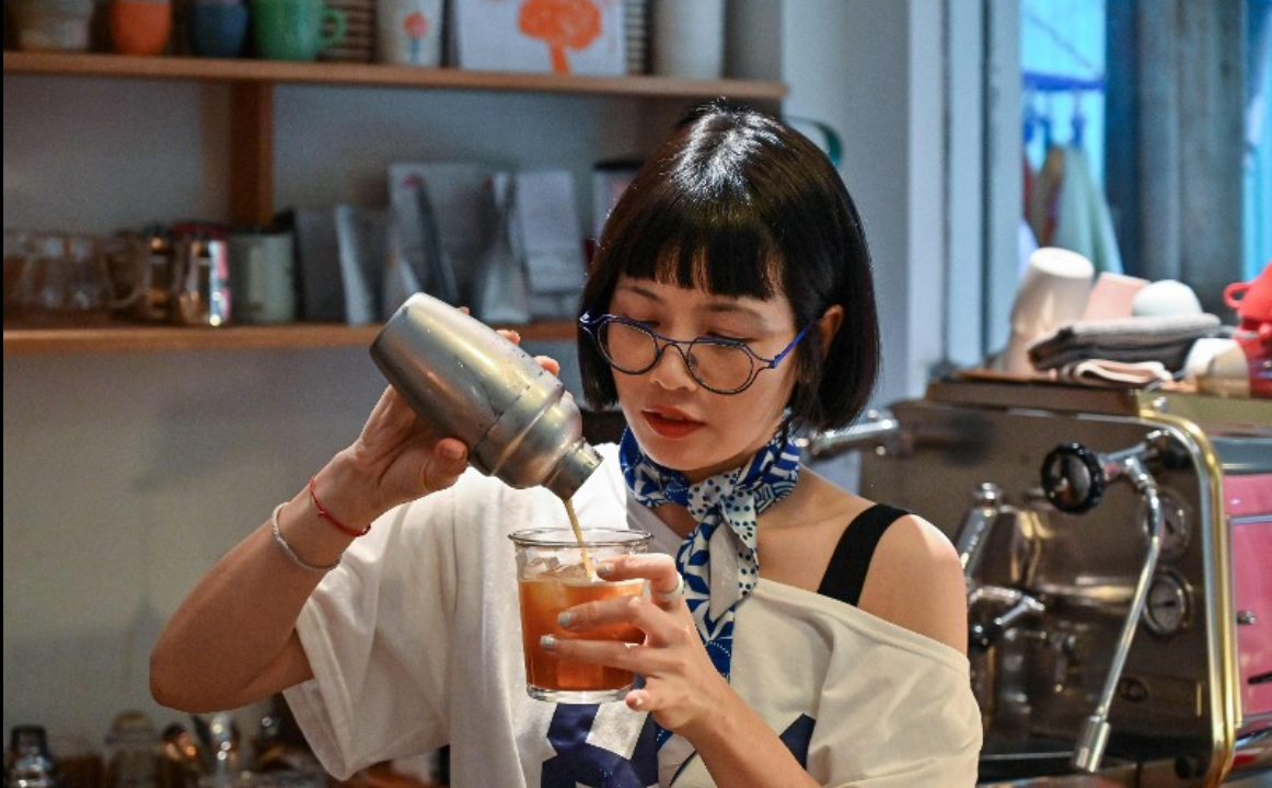 coffee house owner Nguyen Thi Hue making a drink during an interview at her cafe in Hanoi.