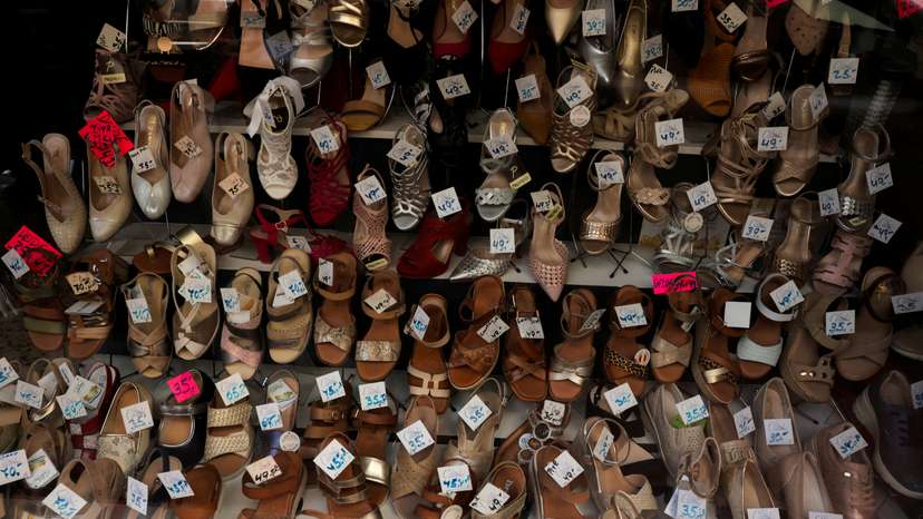 Shoes are displayed with the price in Euros on a showcase of a shoe store, in Ronda