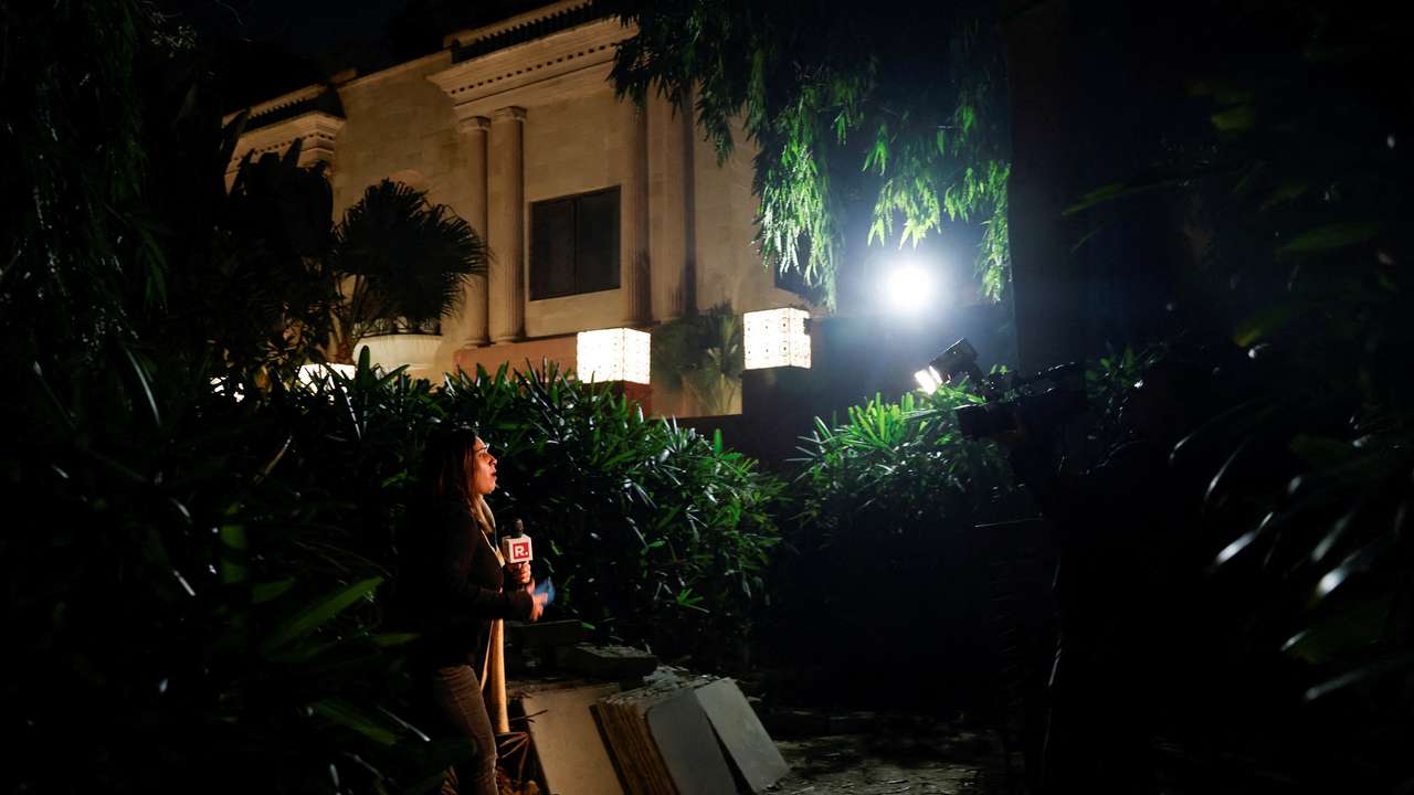 A reporter works outside the Israeli embassy, following a reported explosion nearby, in New Delhi
