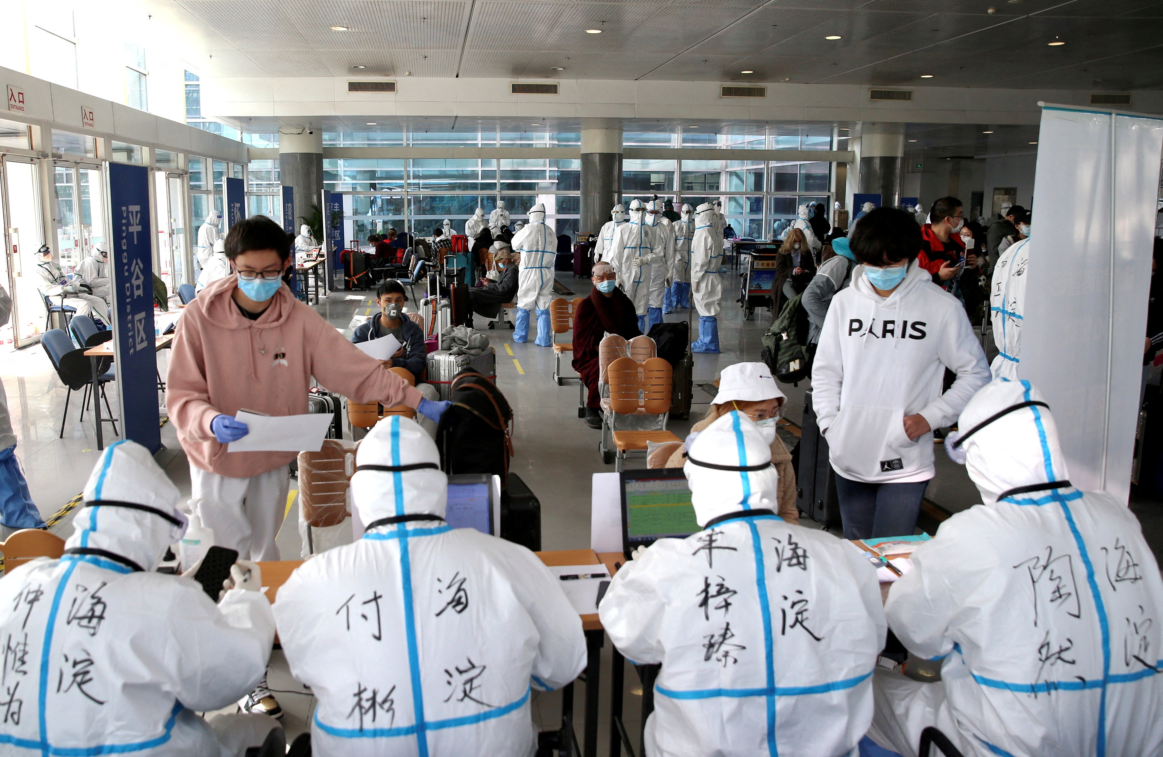 FILE PHOTO: Passengers register their information at the New China International Exhibition Center, a transit hub to screen incoming passengers from the Beijing Capital International Airport for COVID-19
