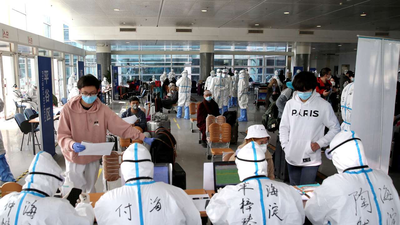 FILE PHOTO: Passengers register their information at the New China International Exhibition Center, a transit hub to screen incoming passengers from the Beijing Capital International Airport for COVID-19