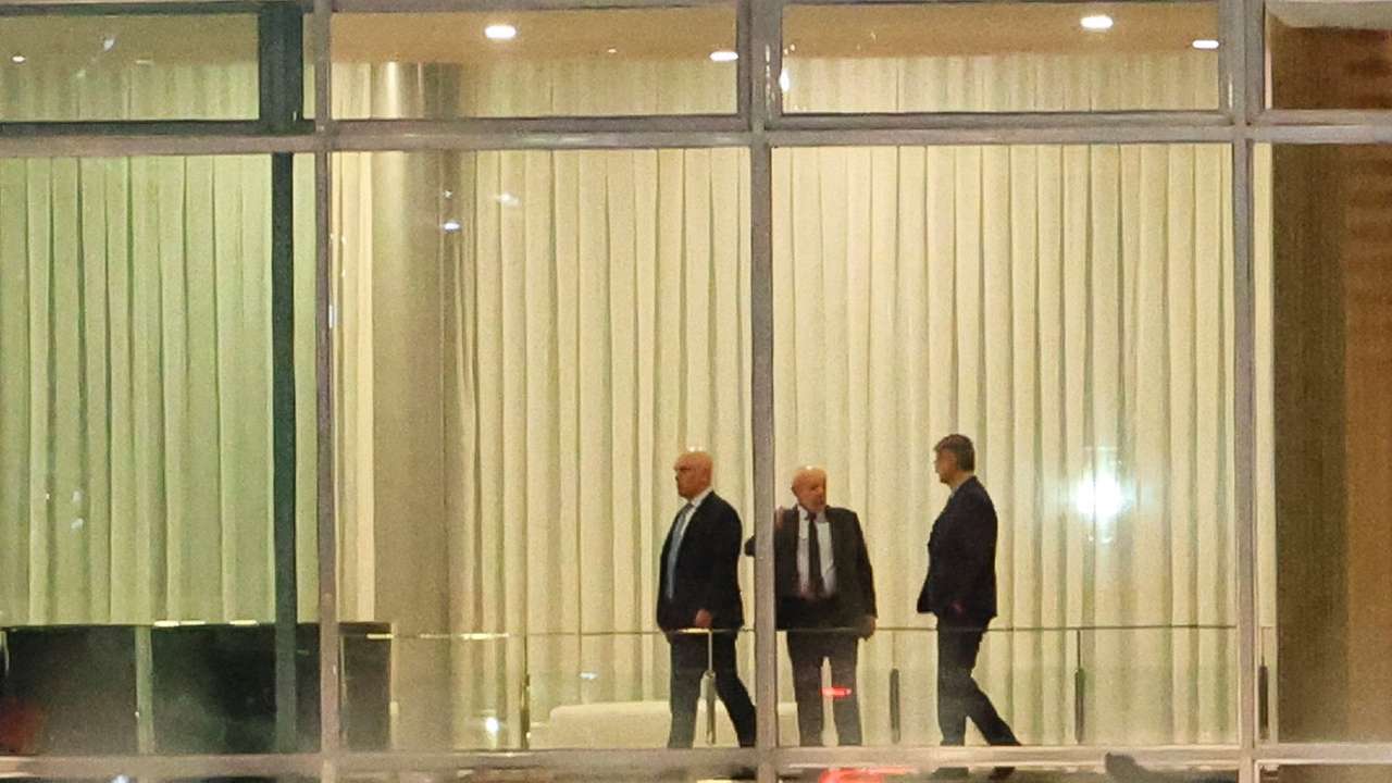 Brazil's Supreme Court Judge Alexandre de Moraes stands next to Brazil's President Luiz Inacio Lula da Silva and Brazil's Prosecutor General Paulo Gonet after a dinner at the Alvorada Palace in Brasilia