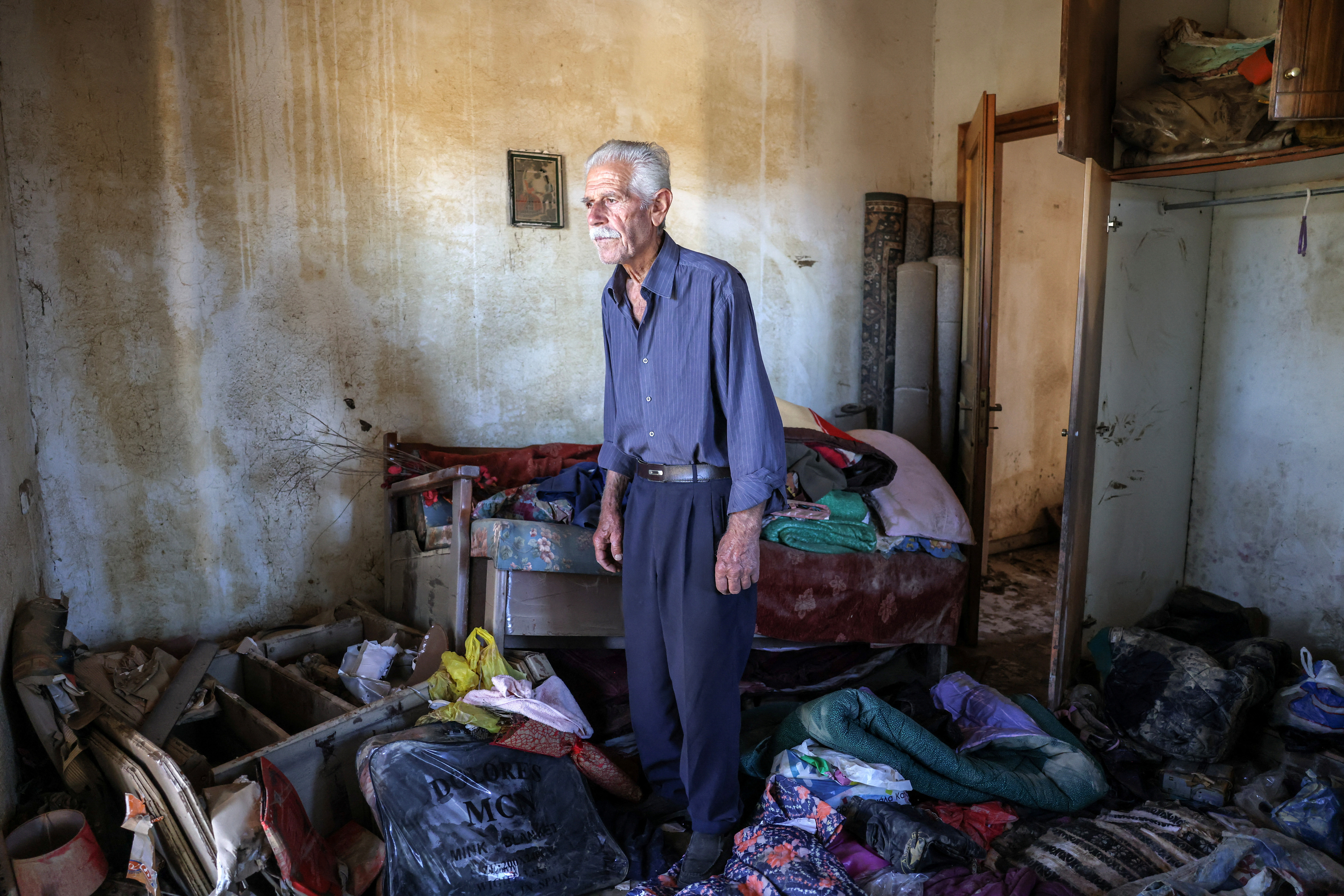 Vassilis Tsatsarelis, 80, stands among debris and his belongings at his damaged house, in the aftermath of Storm Daniel, in the village of Metamorfosi