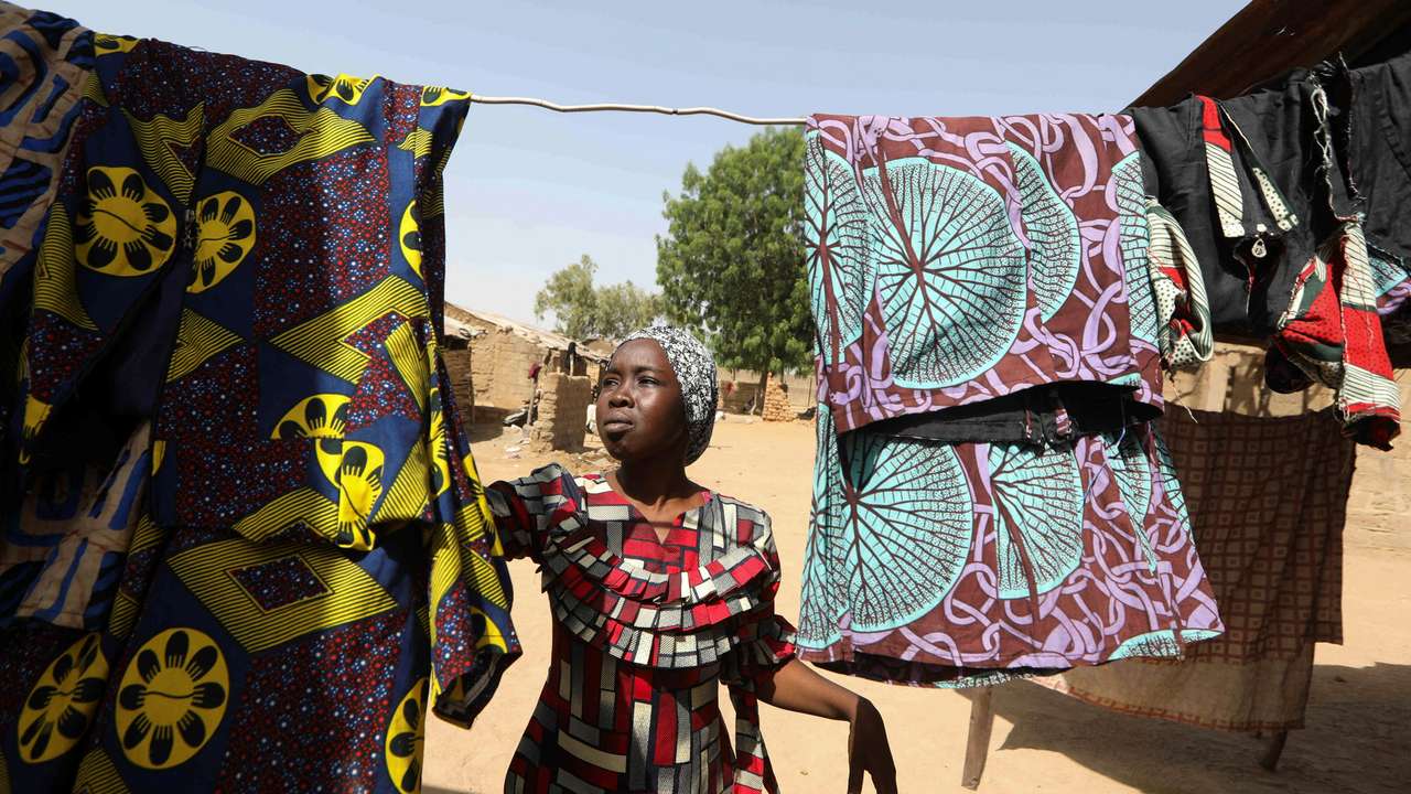 Yagana Yamani, 25, one of the 276 schoolgirls kidnapped from their dormitory by Boko Haram Islamist militants in 2014, spreads her laundry on a clothesline in her home in Chibok, Nigeria April 7, 2024. REUTERS/Temilade Adelaja
