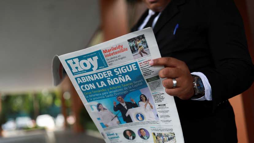 A man reads a newspaper a day after the general election in Santo Domingo