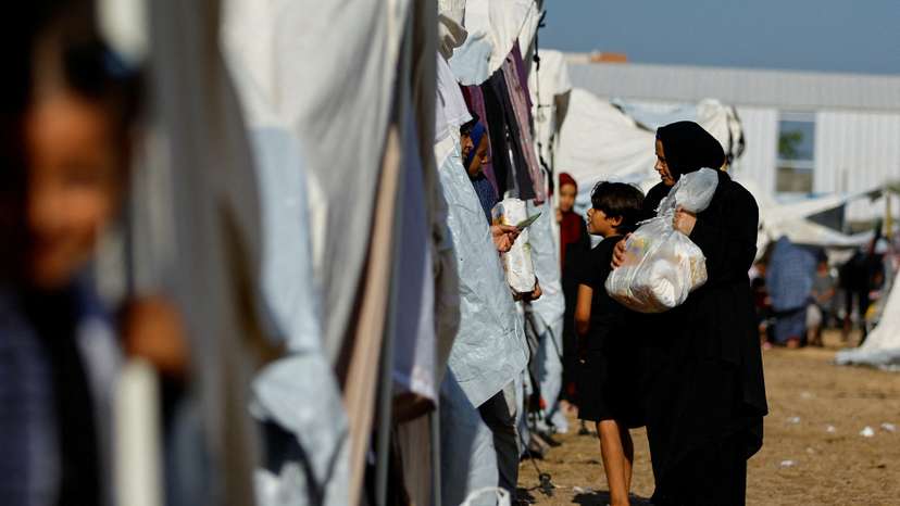 FILE PHOTO: Palestinians, who fled their houses amid Israeli strikes, take shelter at a tent camp at a United Nations-run centre, in Khan Younis