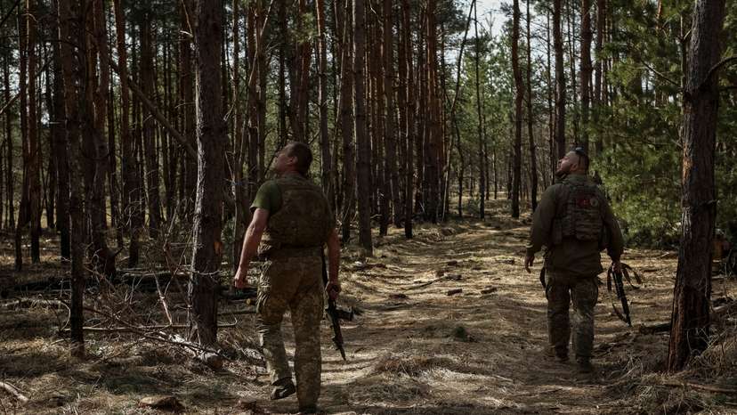 Ukrainian servicemen look into the sky for Russian drones at a position near a frontline in Donetsk region