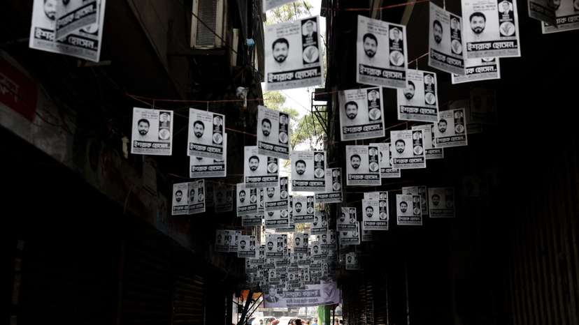 Election campaign posters hang over a street a day ahead of the national election in Dhaka
