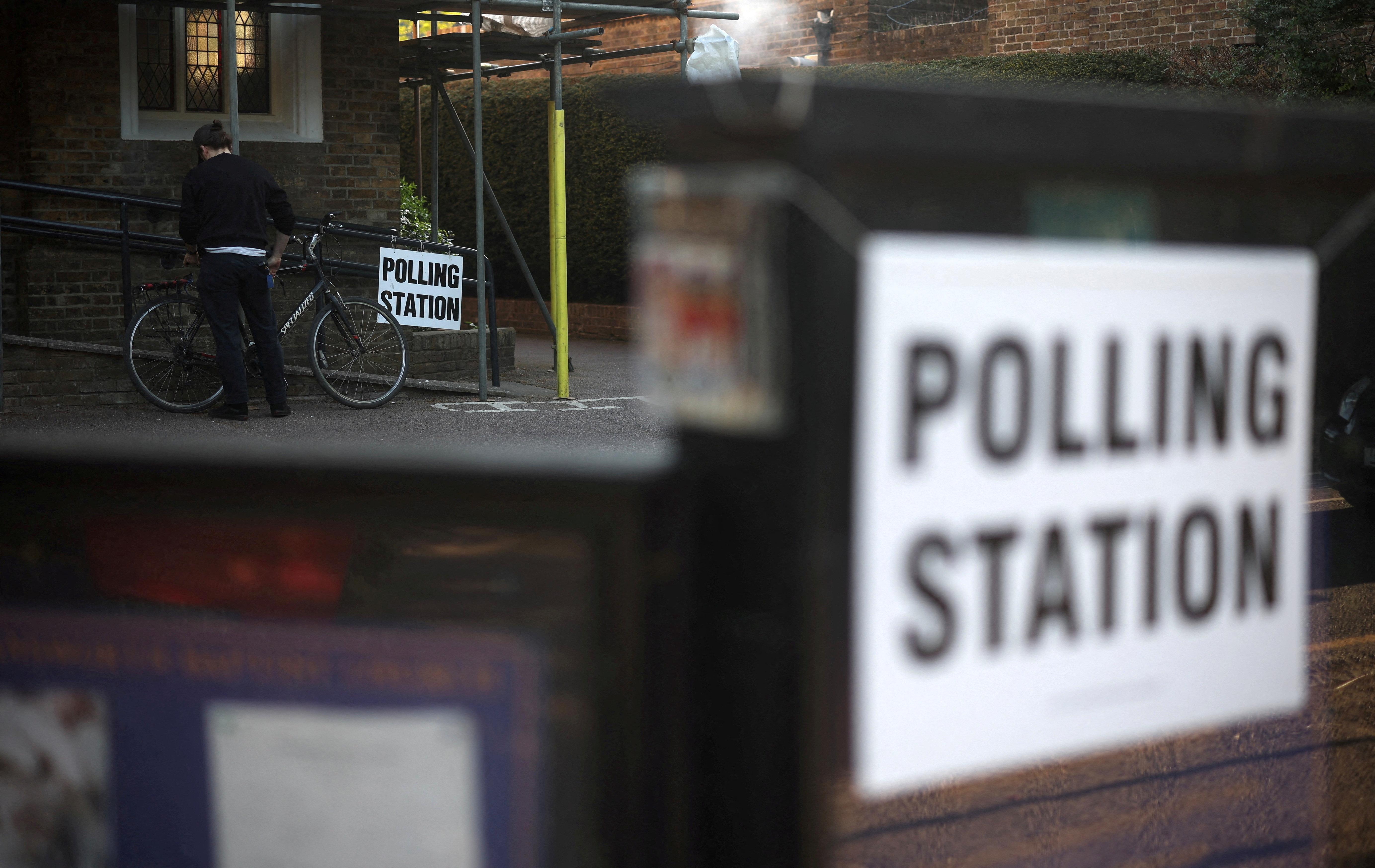 FILE PHOTO: A man unlocks his bicycle after voting at a polling station in Rickmansworth