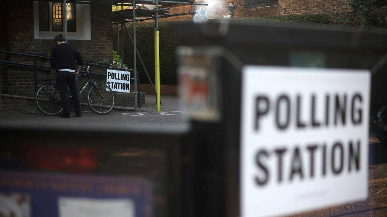 FILE PHOTO: A man unlocks his bicycle after voting at a polling station in Rickmansworth