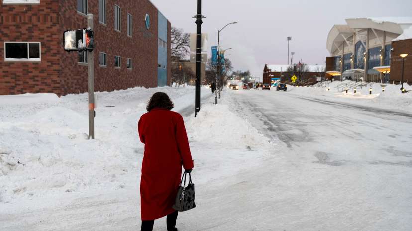 A woman walks down a street amid sub-zero temperatures, ahead of the Iowa state caucus vote in Des Moines