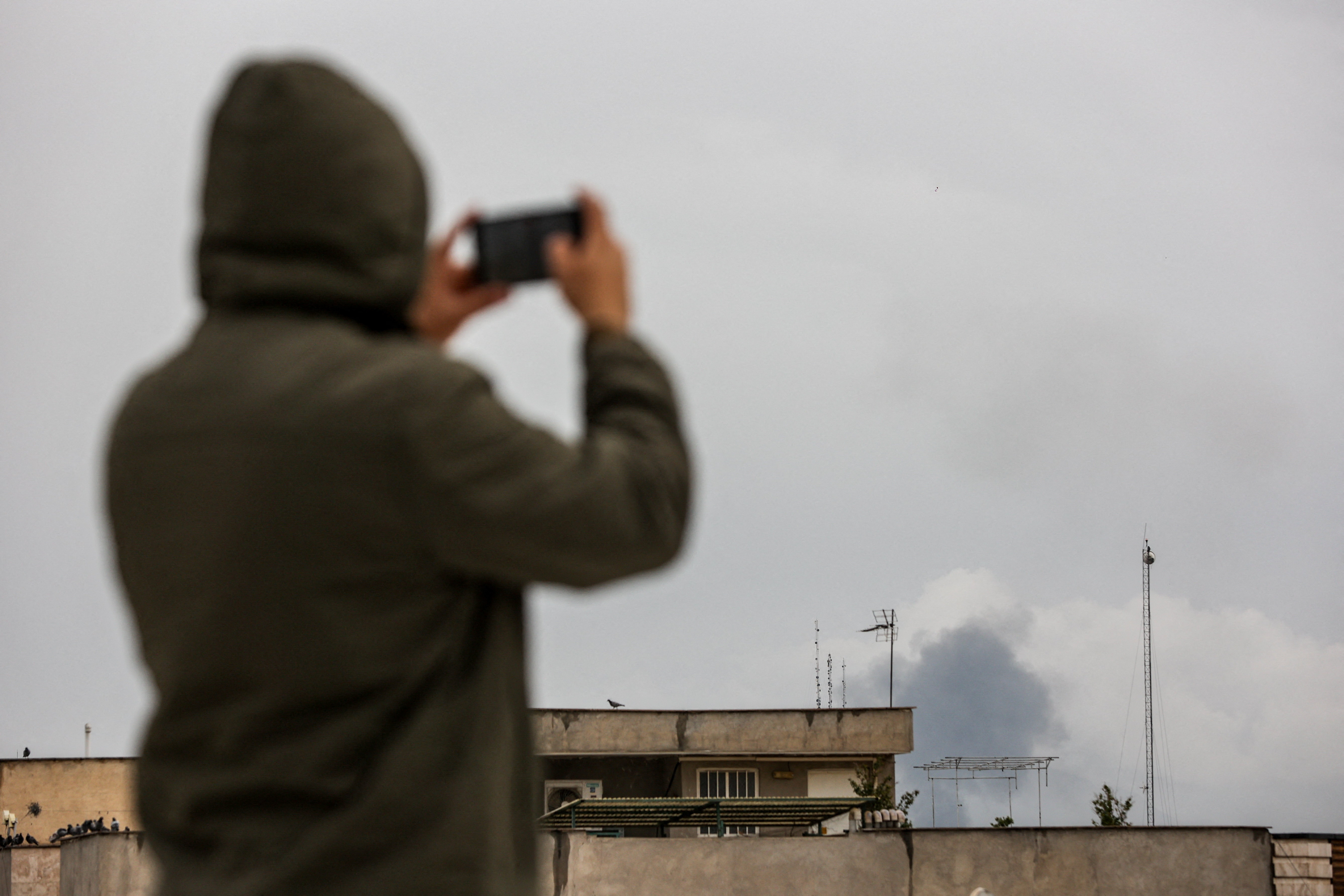 Smoke rises following a strike, in Tehran