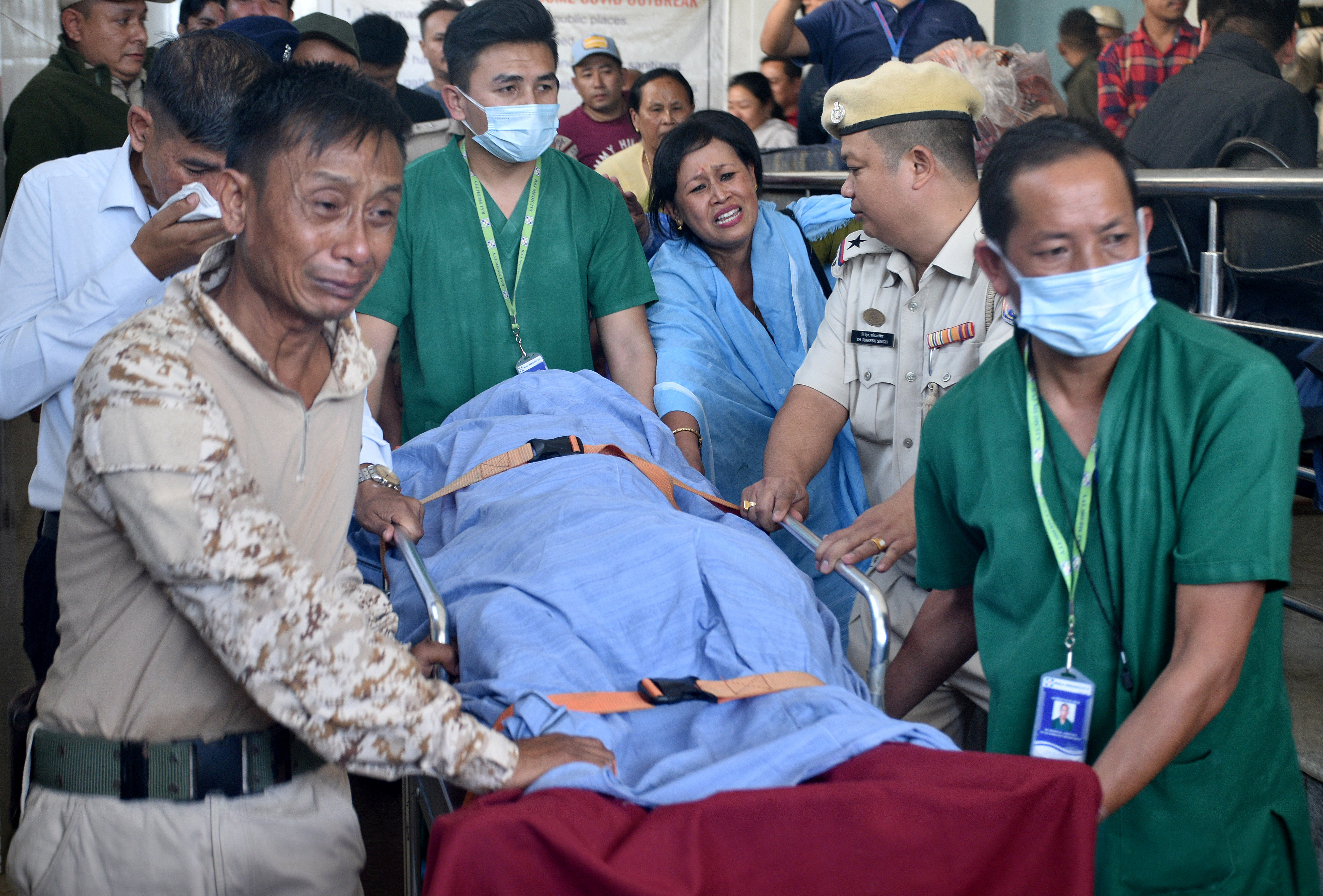 Relatives and police officers mourn as they carry the body of Chingtham Anand, a SDPO, outside a hospital in Imphal
