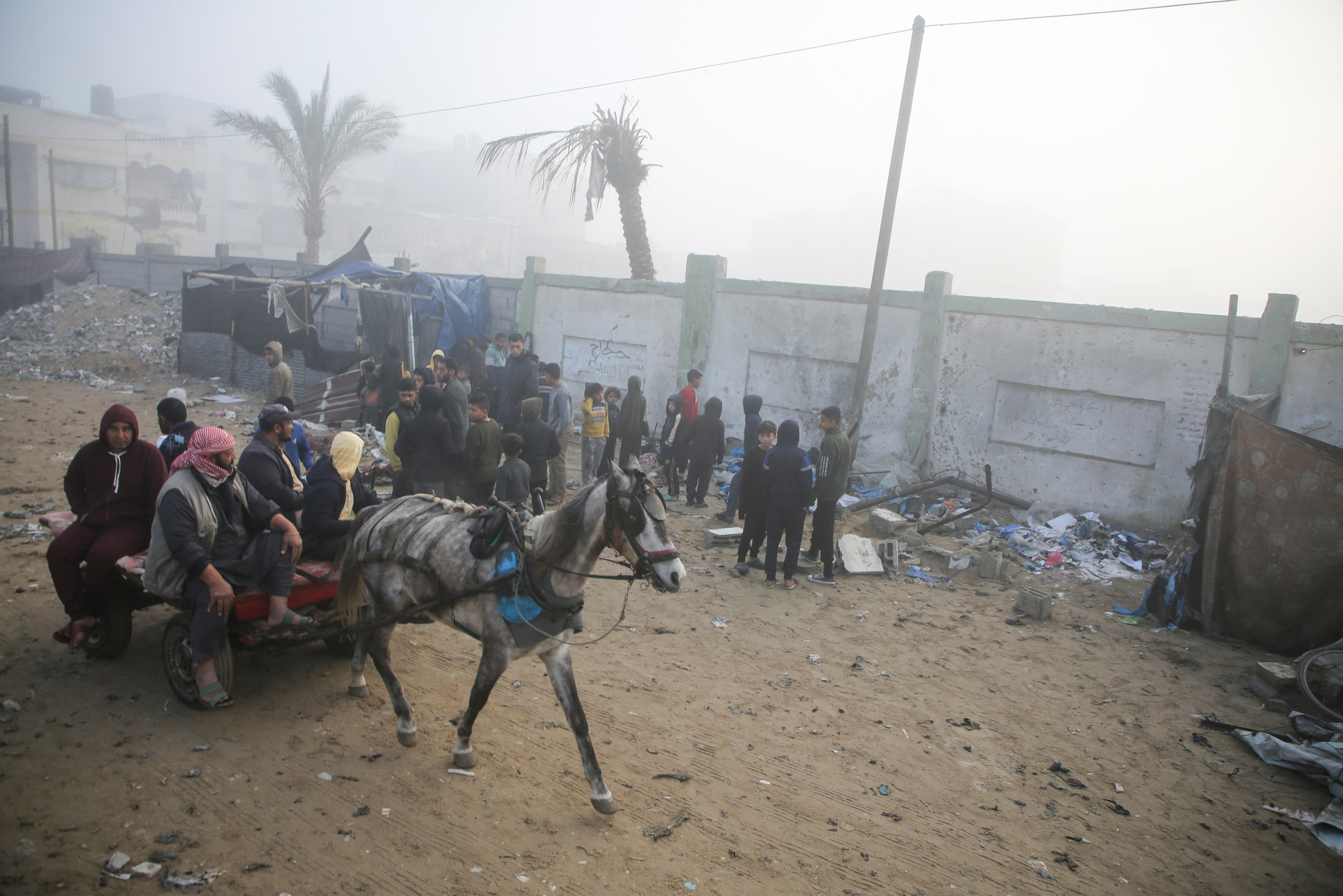 Palestinians inspect the damage to a tent for displaced people, after an Israeli airstrike, in Khan Younis