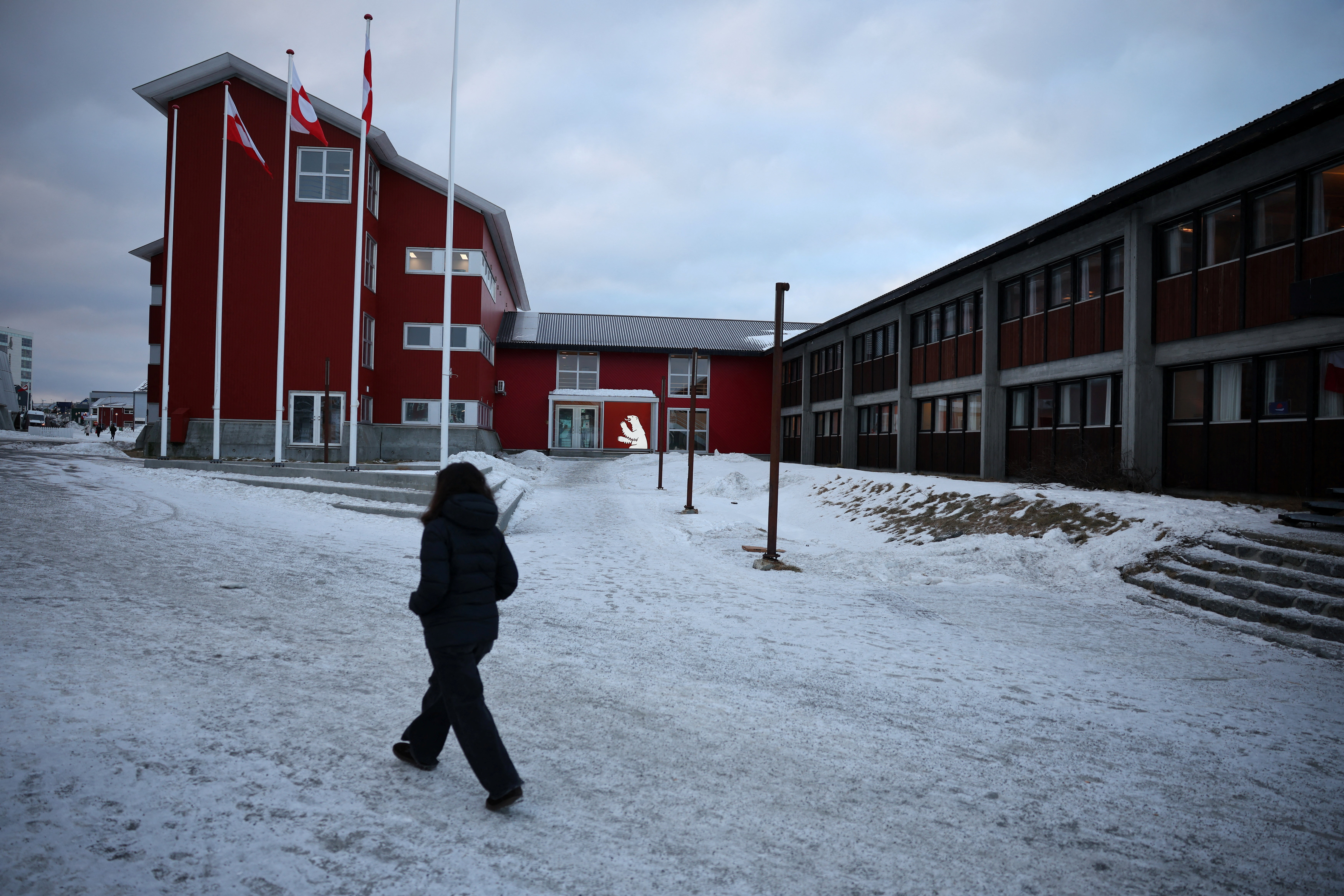 Person walks in front of the parliament in Nuuk