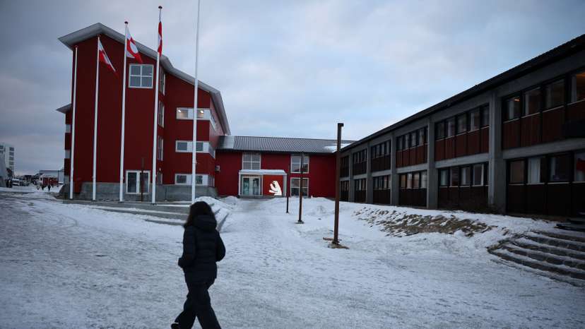Person walks in front of the parliament in Nuuk