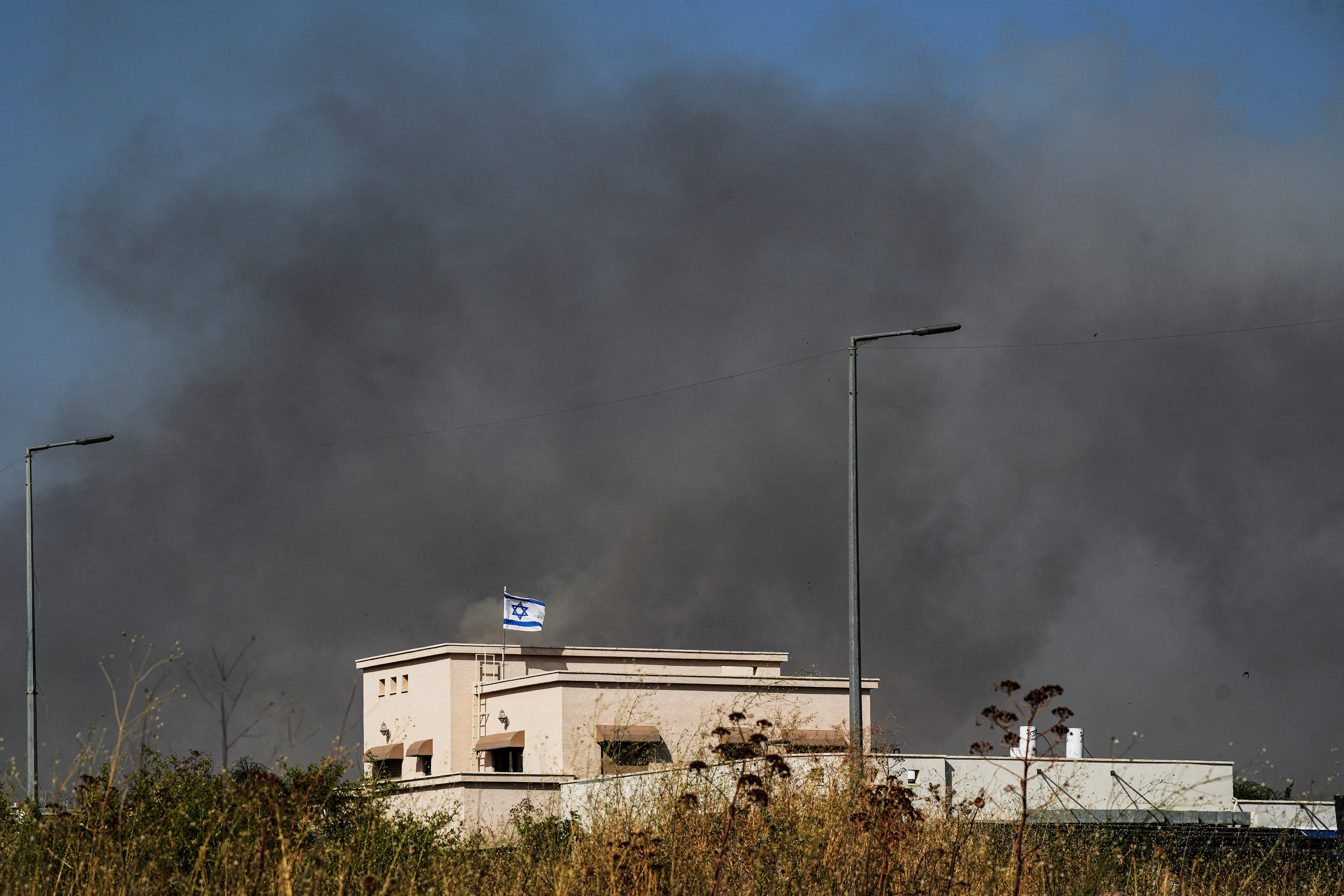 Smoke billows behind a house following over border attacks from Lebanon, in Katzrin in the Israeli-occupied Golan Heights