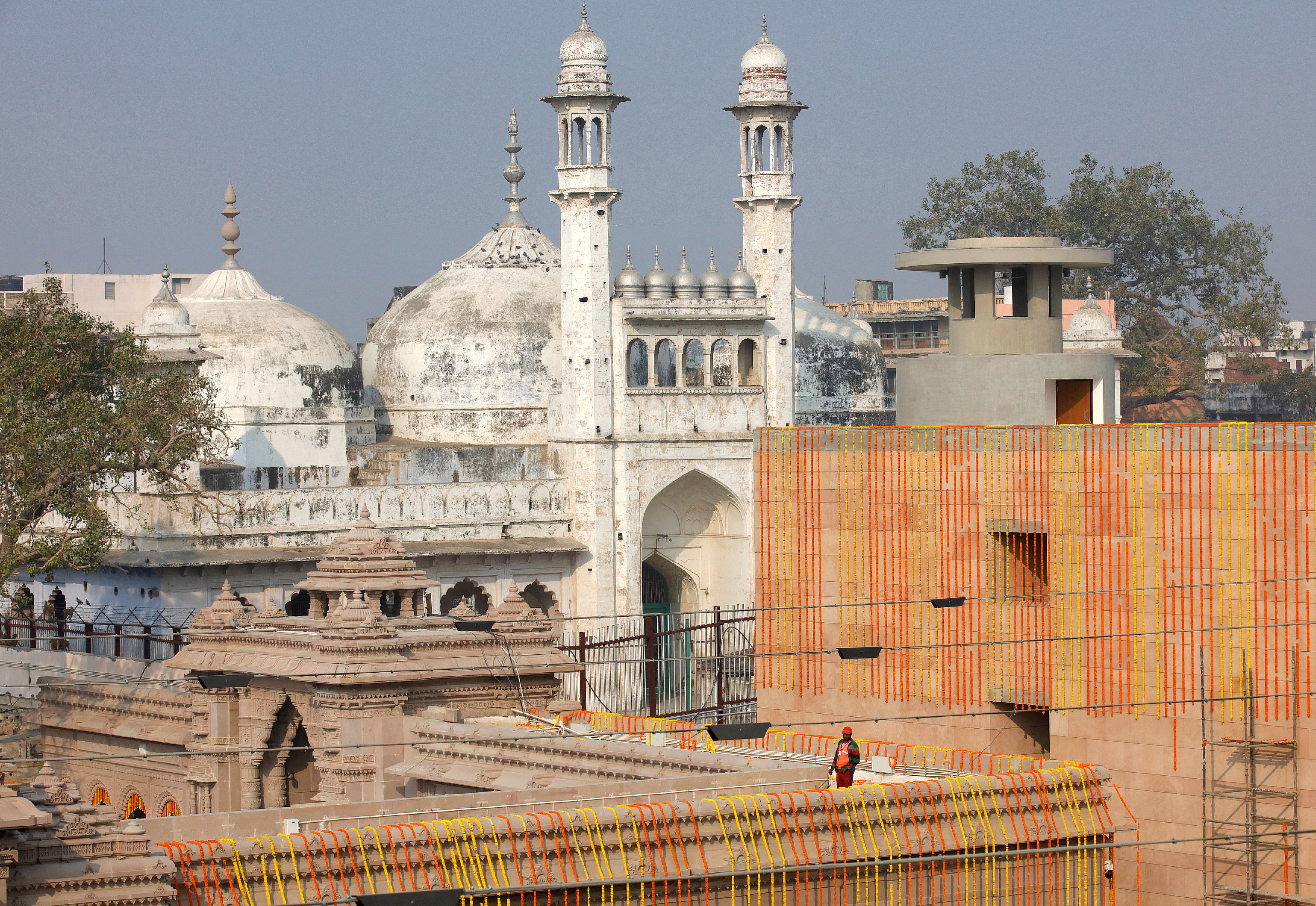 FILE PHOTO: A worker stands on a temple rooftop adjacent to the Gyanvapi Mosque