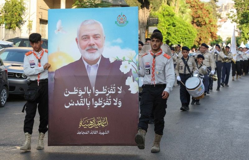 Members of Imam al-Mahdi scouts carry a picture depicting late Hamas leader Ismail Haniyeh, during a protest condemning his killing, in Sidon