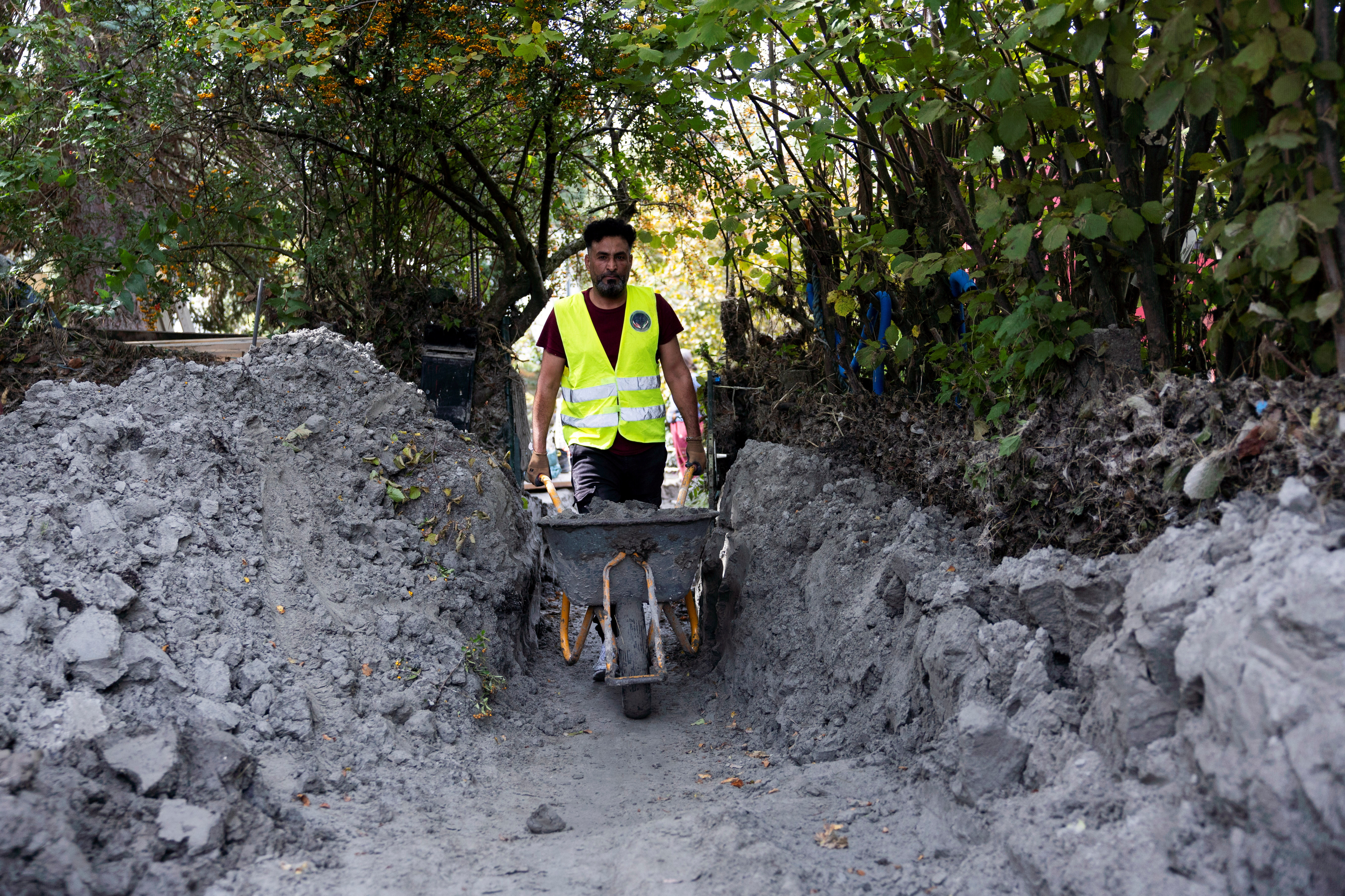 Syrian migrants help with the clean-up of the floods