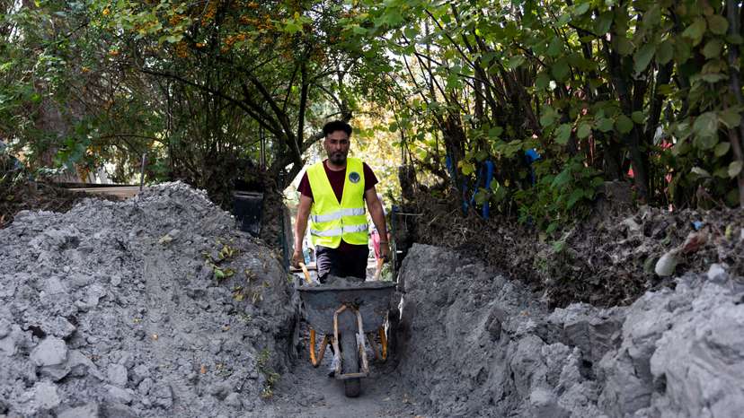 Syrian migrants help with the clean-up of the floods