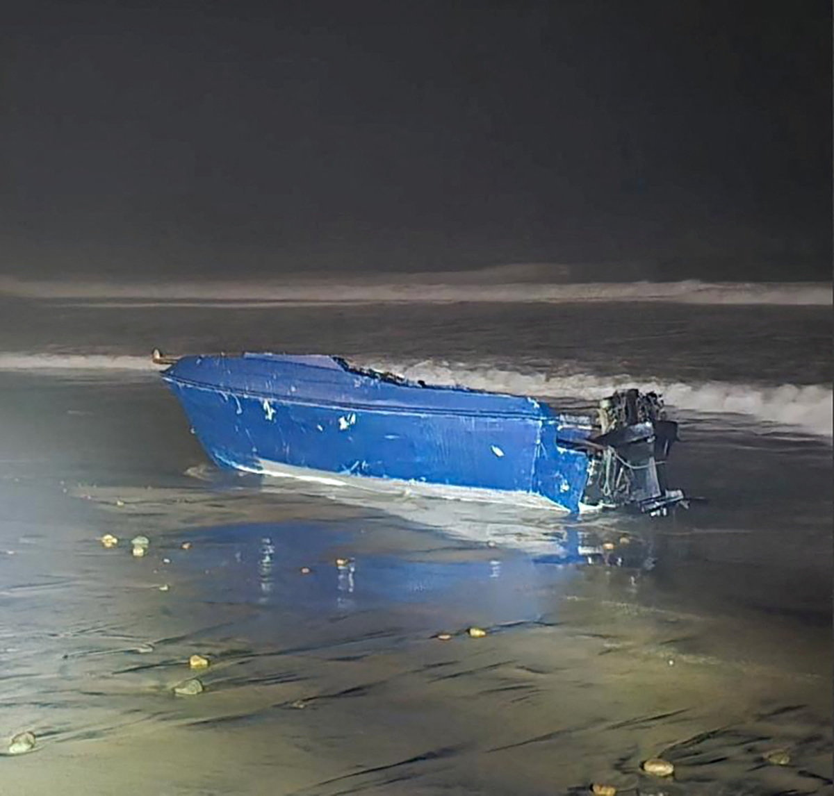 A vessel which capsized off the coast lies on a beach in Imperial Beach