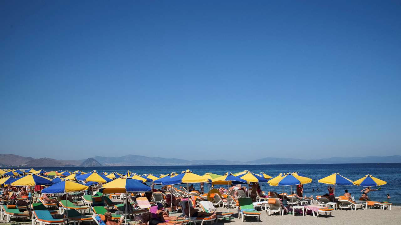 FILE PHOTO: Tourists relax on the beach of Mediterranean Sea at the island of Kos, Greece