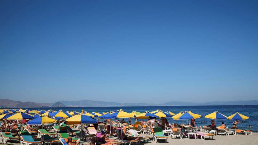 FILE PHOTO: Tourists relax on the beach of Mediterranean Sea at the island of Kos, Greece