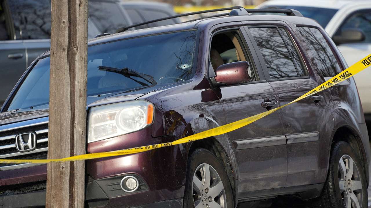 Members of U.S. Immigration and Customs Enforcement (ICE) stand guard after a driver of a vehicle was shot in Minneapolis