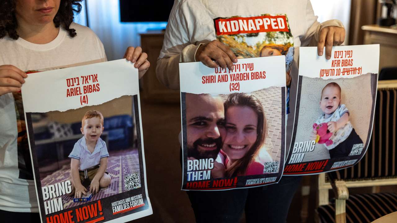 Bibas Levy holds with her friend Ulus pictures of her brother Yarden who was kidnapped with his wife and 2 children in Geneva