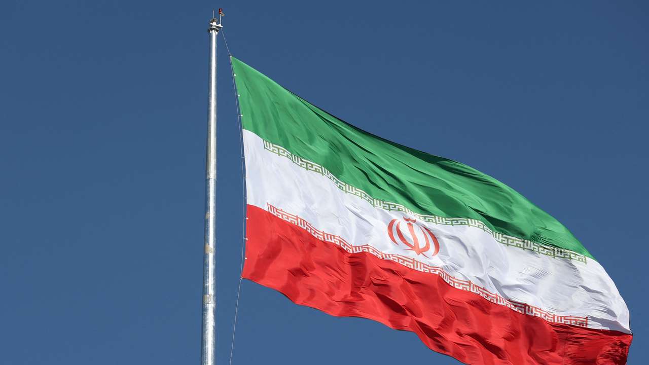 The Iranian flag is seen flying over a street in Tehran