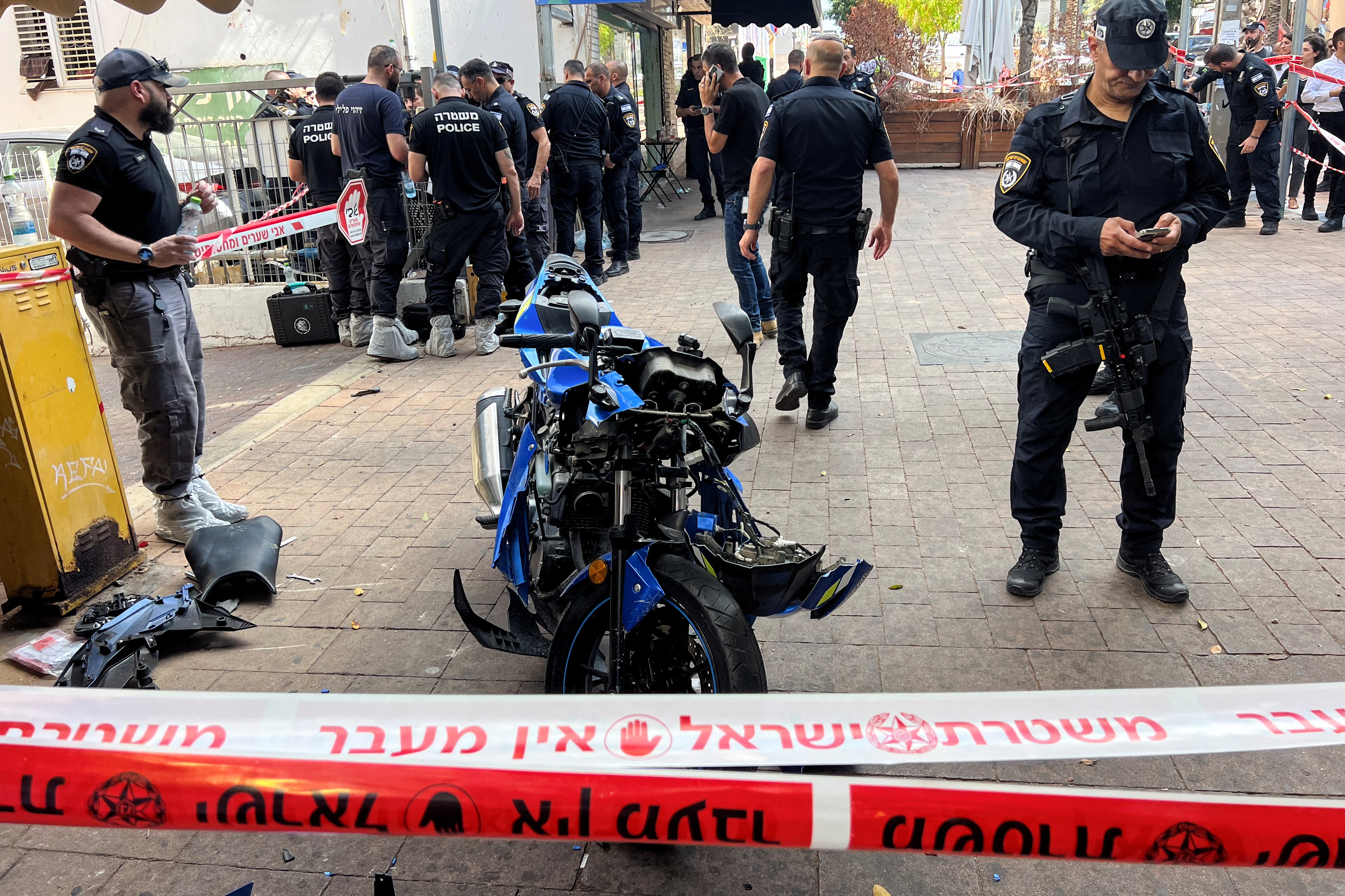 Israeli police stand around the motorbike of the attacker following a stabbing attack in Hadera