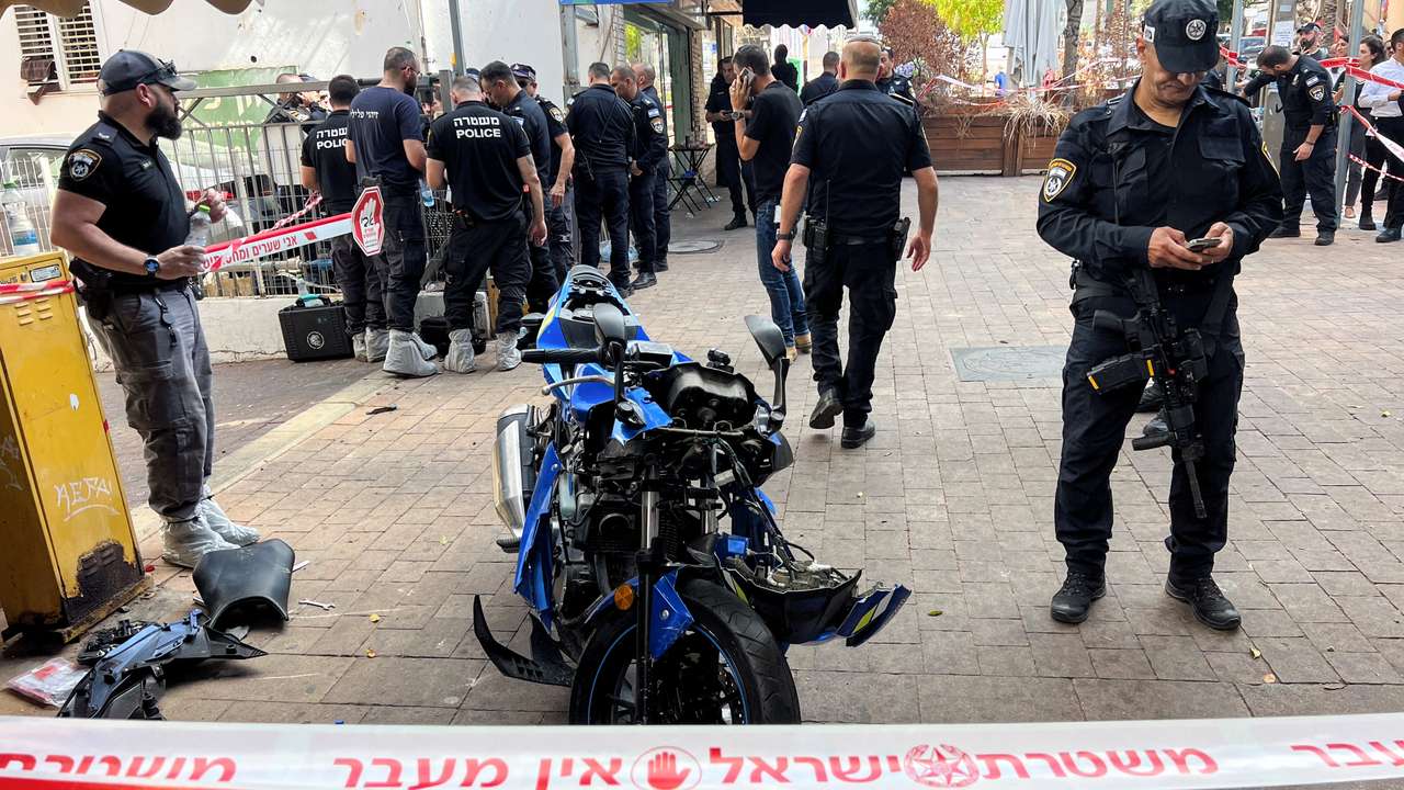 Israeli police stand around the motorbike of the attacker following a stabbing attack in Hadera