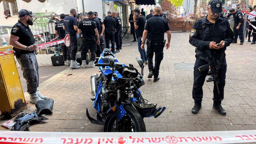 Israeli police stand around the motorbike of the attacker following a stabbing attack in Hadera