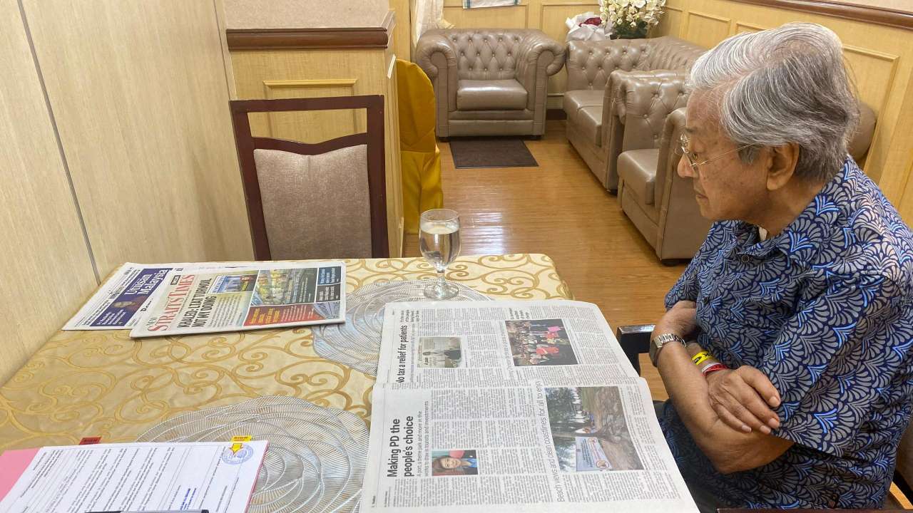FILE PHOTO: FILE PHOTO: Malaysia's former Prime Minister Mahathir Mohamad reads news paper as he hospitalised for an infection at the National Heart Institute in Kuala Lumpur