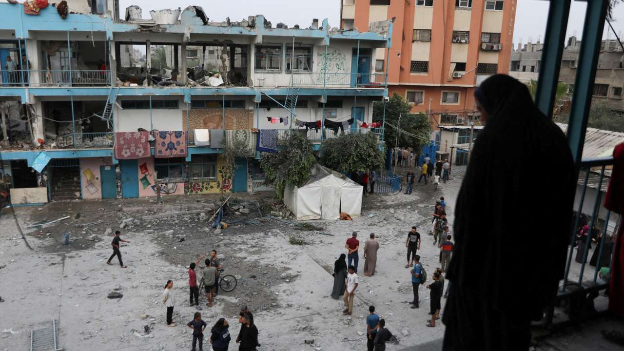 Palestinians inspect the site of an Israeli strike on a UNRWA school sheltering displaced people, in Nuseirat refugee camp