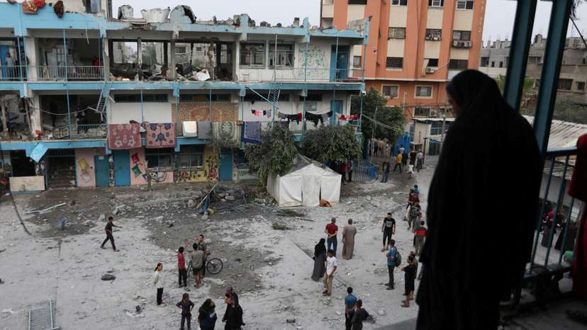 Palestinians inspect the site of an Israeli strike on a UNRWA school sheltering displaced people, in Nuseirat refugee camp