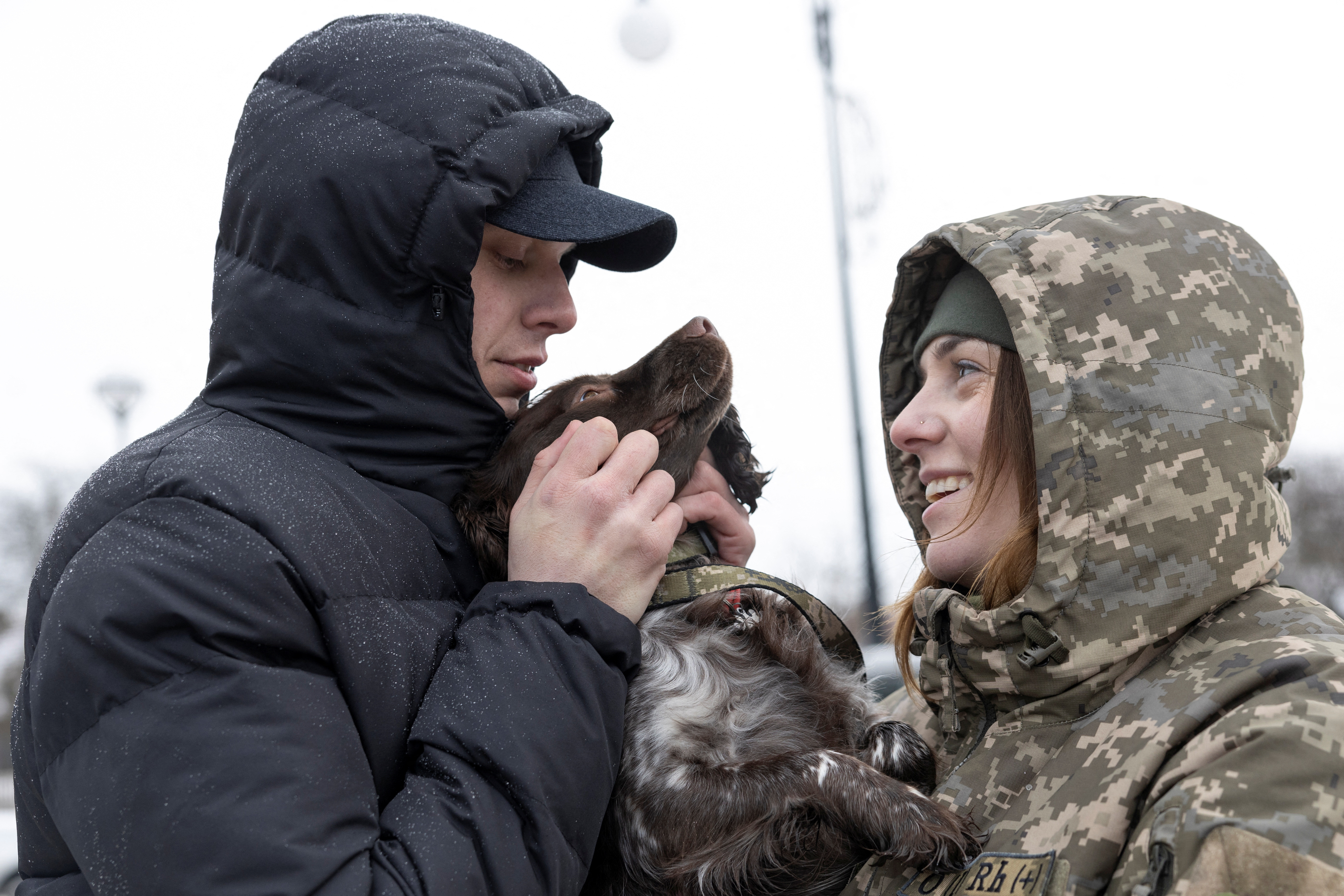 Ukrainian border guard members and former prisoners of war Illia Muzyka and Alina Panina play with Alina's service dog 'Roksi' in Novovolynsk