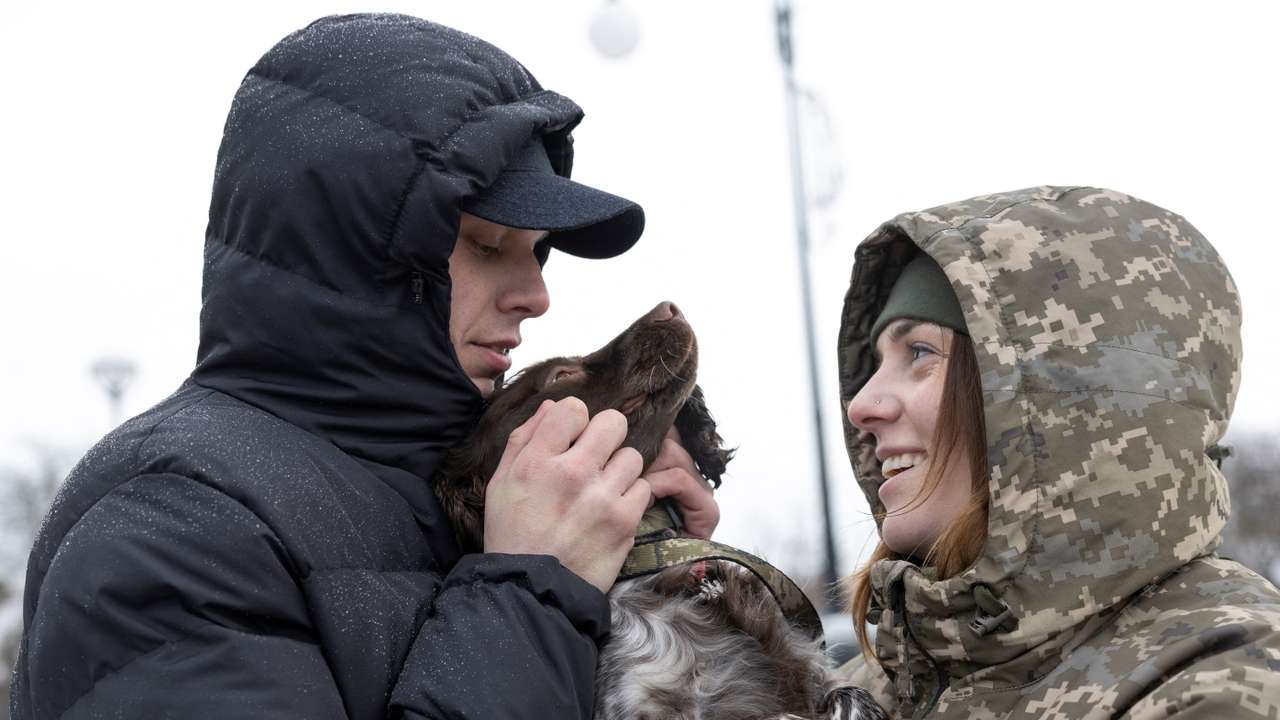 Ukrainian border guard members and former prisoners of war Illia Muzyka and Alina Panina play with Alina's service dog 'Roksi' in Novovolynsk