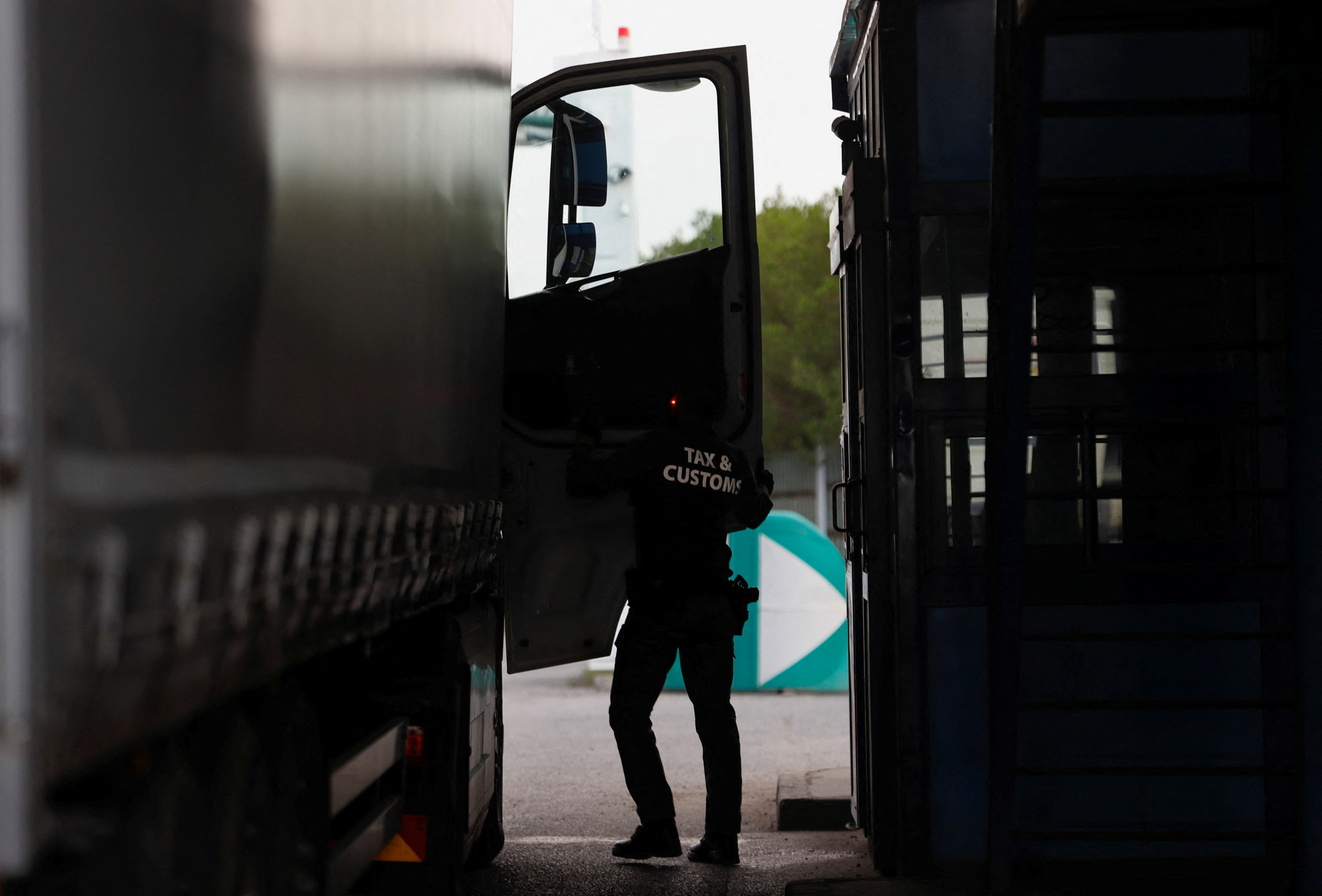 A member of the Tax and Customs Directorate checks an Ukrainian truck at the Hungarian-Ukrainian border, in Zahony