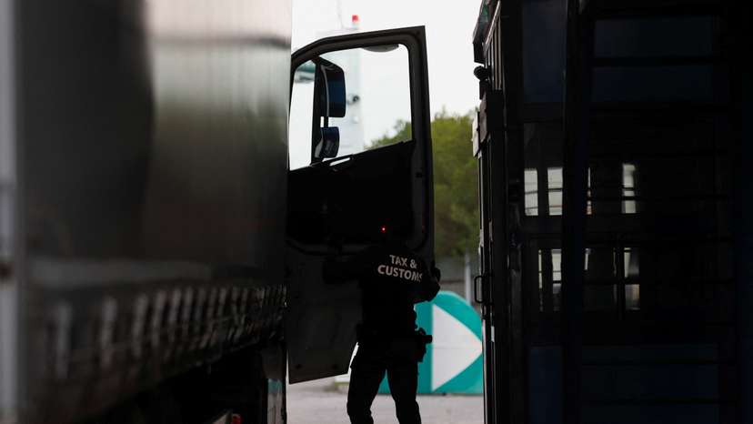 A member of the Tax and Customs Directorate checks an Ukrainian truck at the Hungarian-Ukrainian border, in Zahony